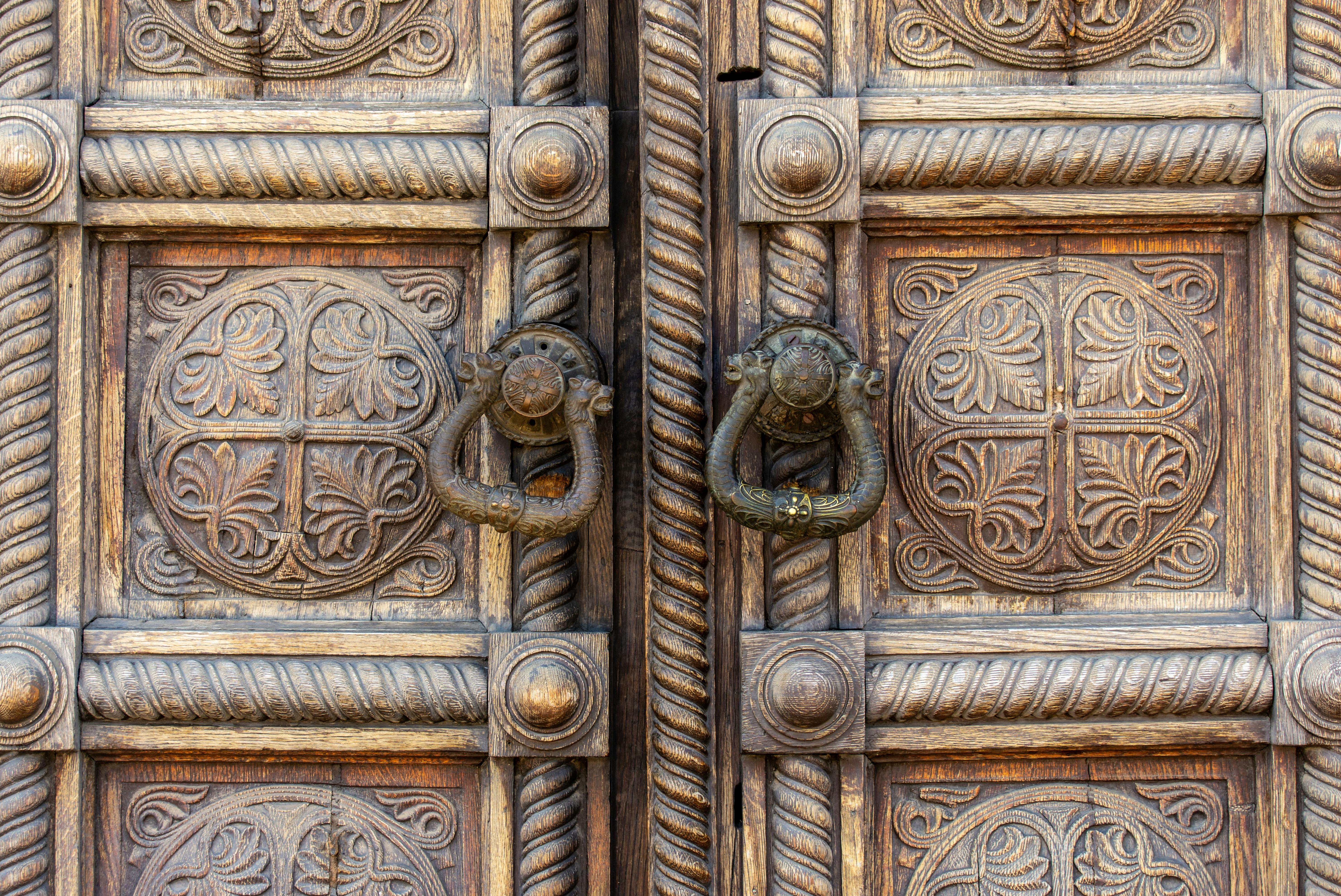 無料 複雑な彫刻とビンテージの取っ手が付いた華やかな木製ドアの詳細なクローズアップ。 写真素材