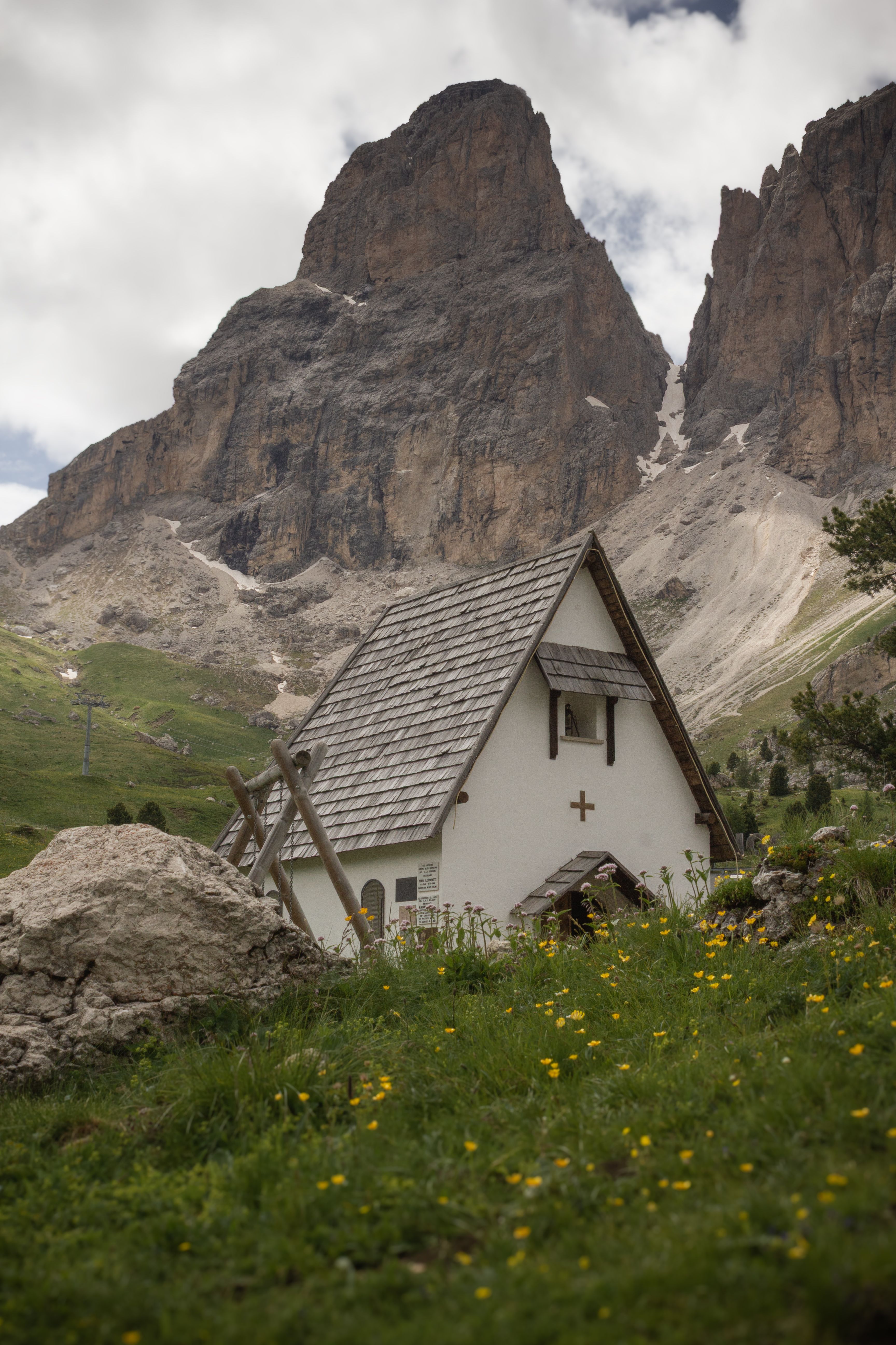 A quaint chapel in the Dolomites with stunning peaks in the background.