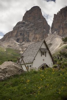 A quaint chapel in the Dolomites with stunning peaks in the background.