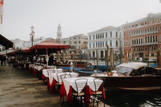 Idyllic Venice scene with canal, outdoor café seating, and classic Italian architecture.