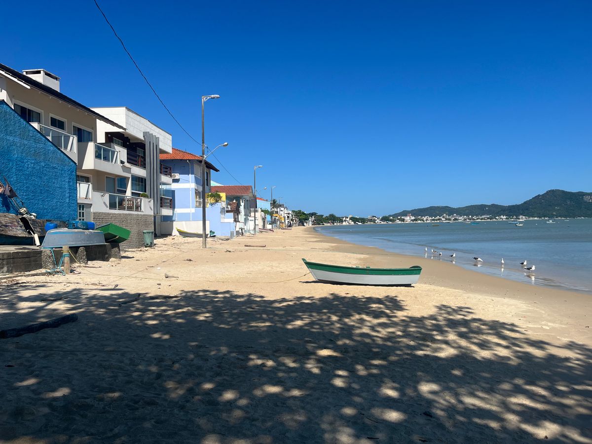 Sunny beach with a fishing boat in Florianópolis