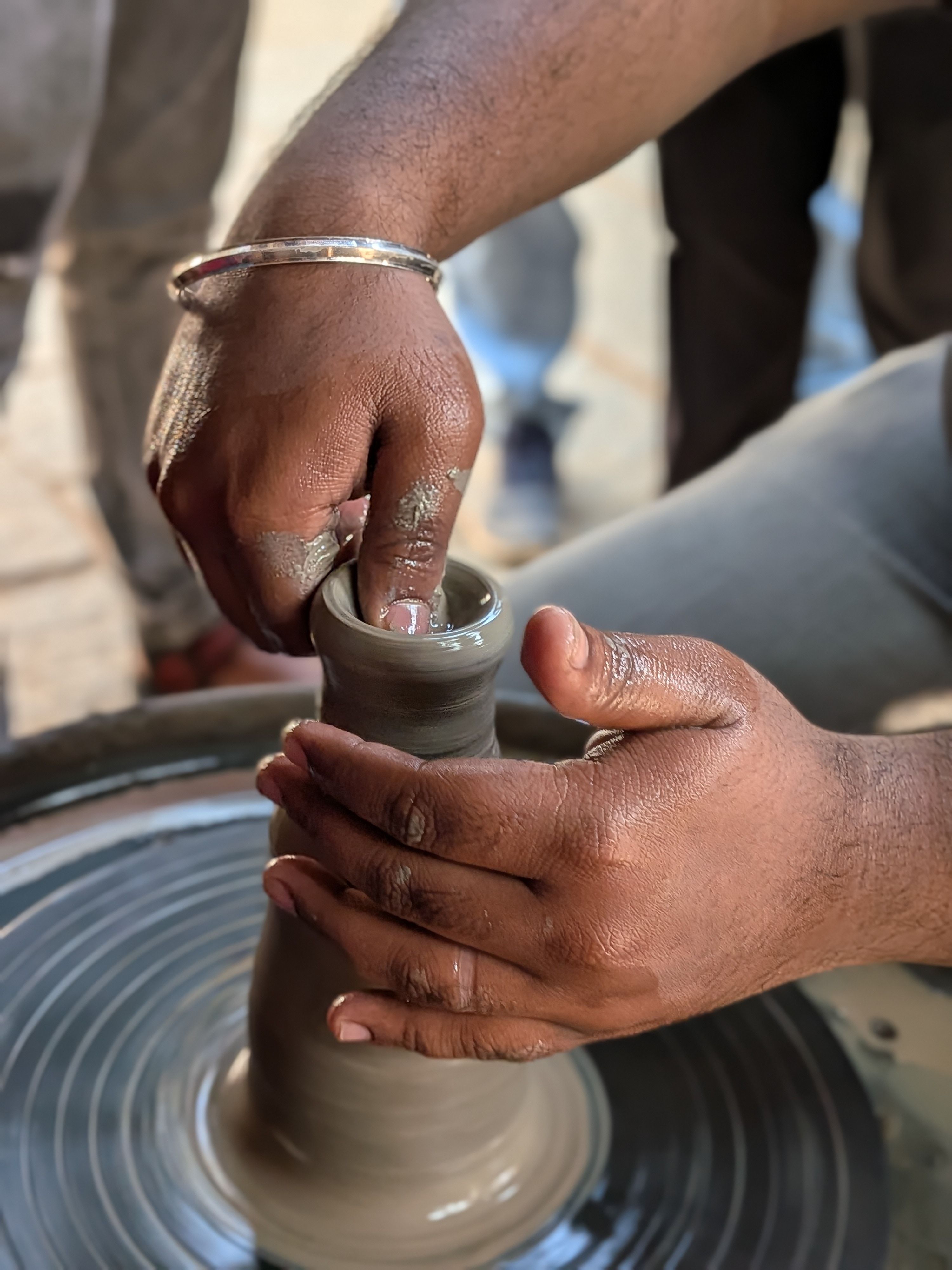 Hands shaping clay on a pottery wheel — photo by Narasimhan AVPL on Pexels