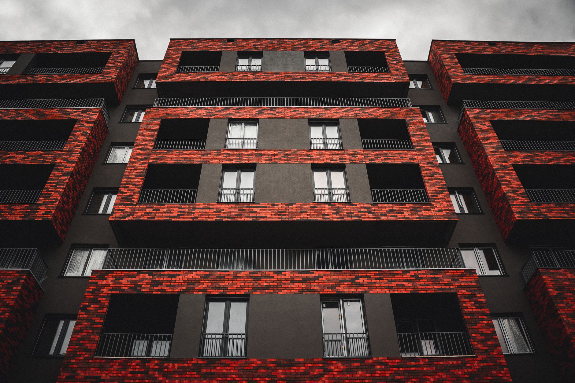 A mid-rise residential block with freshly painted white render and new window frames