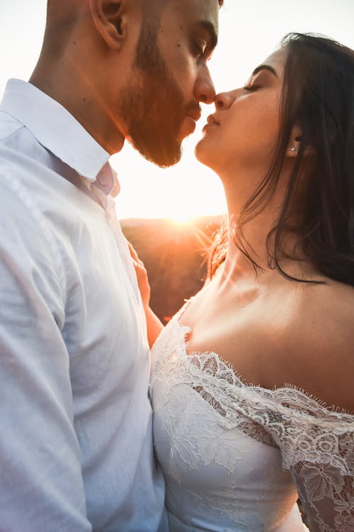 Uomo In Camicia Di Vestito Bianca Che Bacia Donna In Vestito Da Sposa Bianco