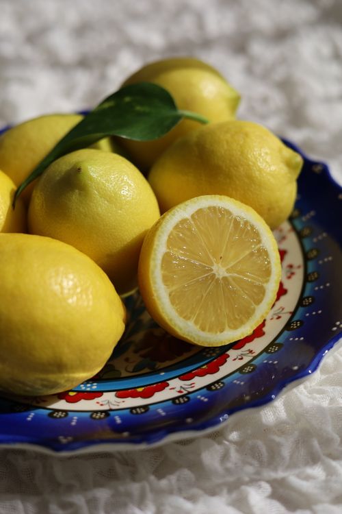 Free Bright lemons arranged beautifully on a patterned ceramic plate. Stock Photo