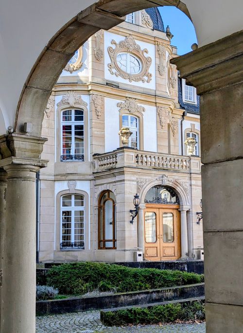 Free View through archway of an ornate European-style mansion entrance featuring intricate stonework. Stock Photo