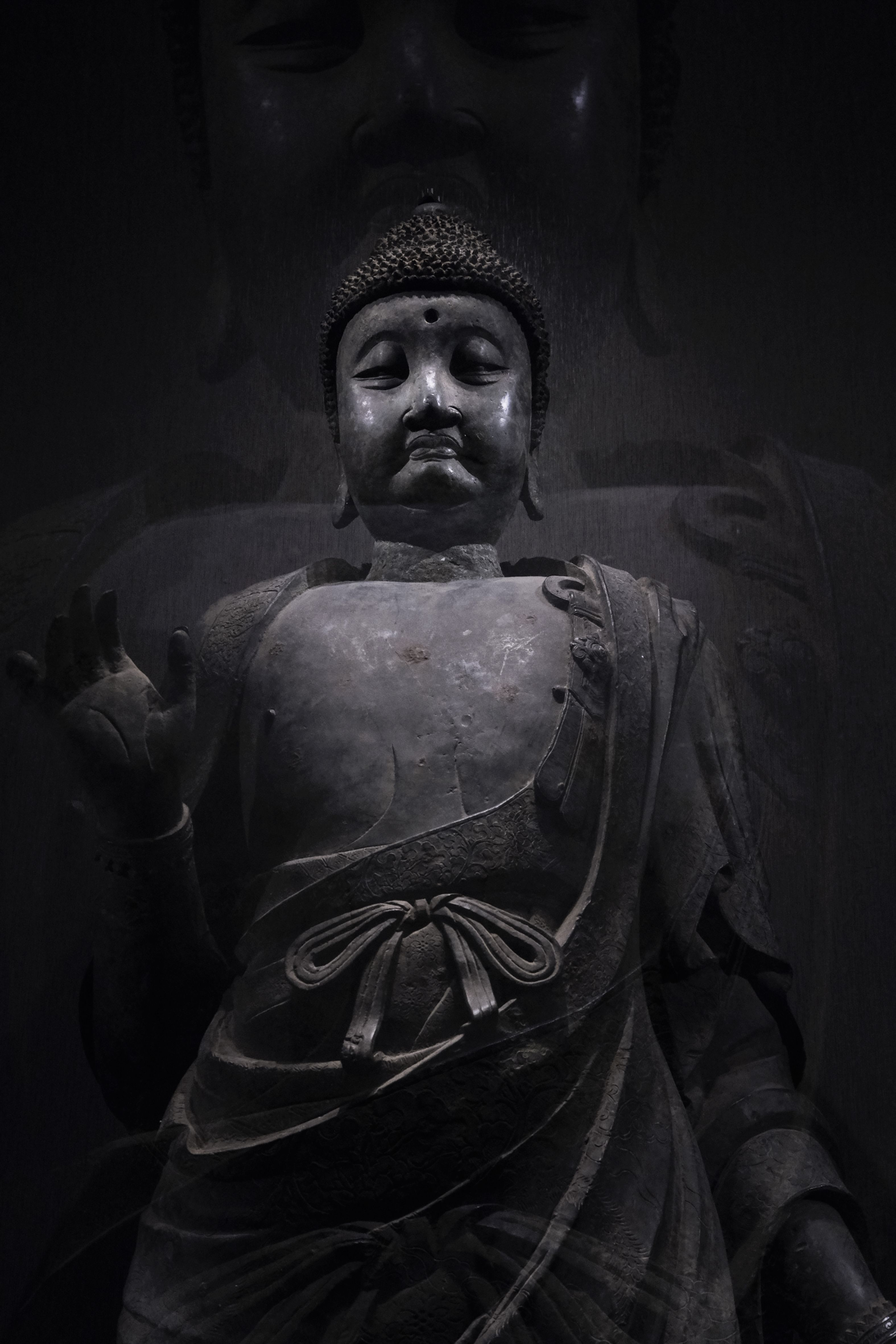 Gratis En mystisk Buddha-statue innhyllet i mørke, som utstråler ro og fred. Arkivbilde