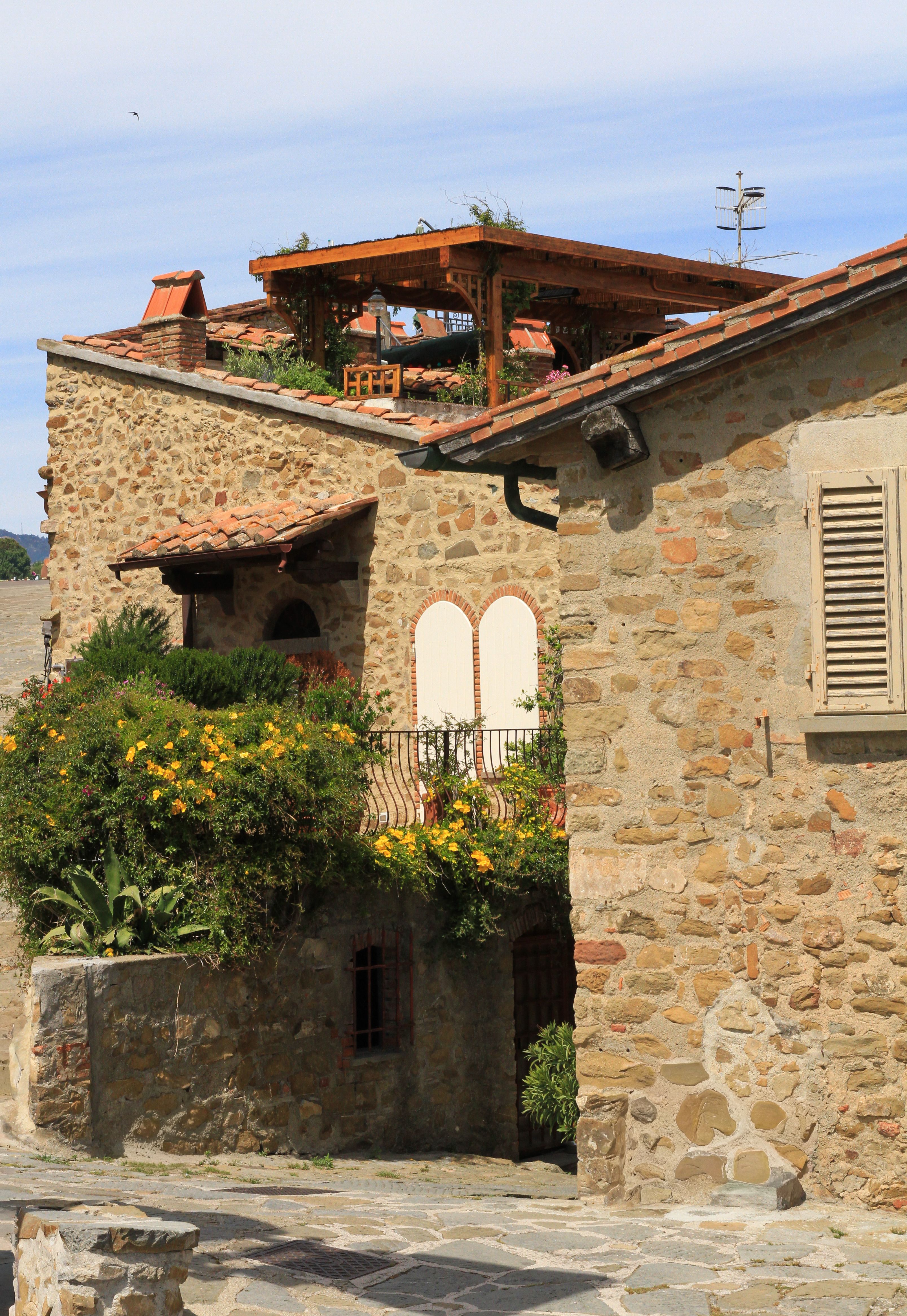 Free Beautiful stone house in Italian village, featuring rustic architecture and lush greenery. Stock Photo