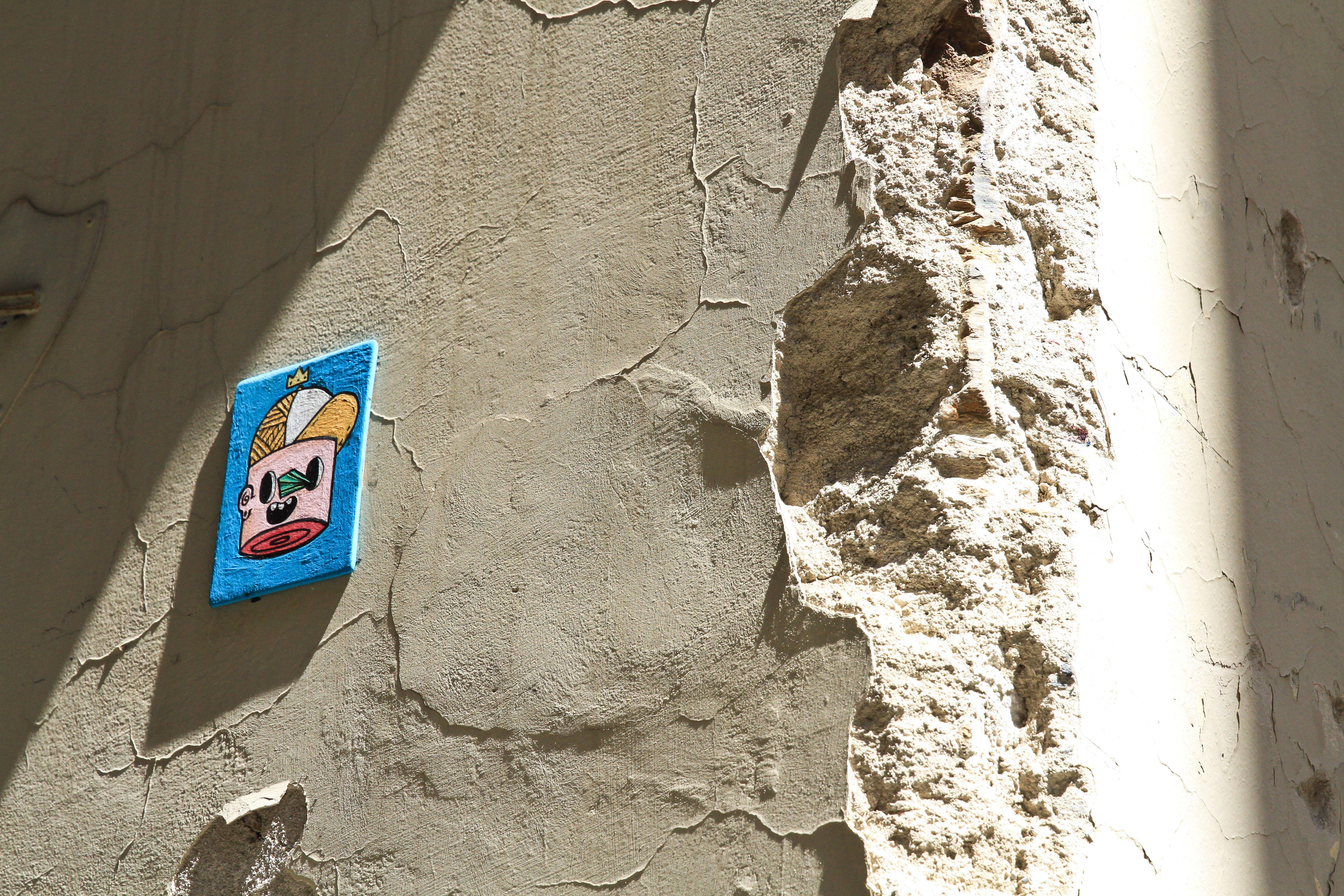 Free Vibrant graffiti art on a textured wall with peeling plaster under bright sunlight. Stock Photo