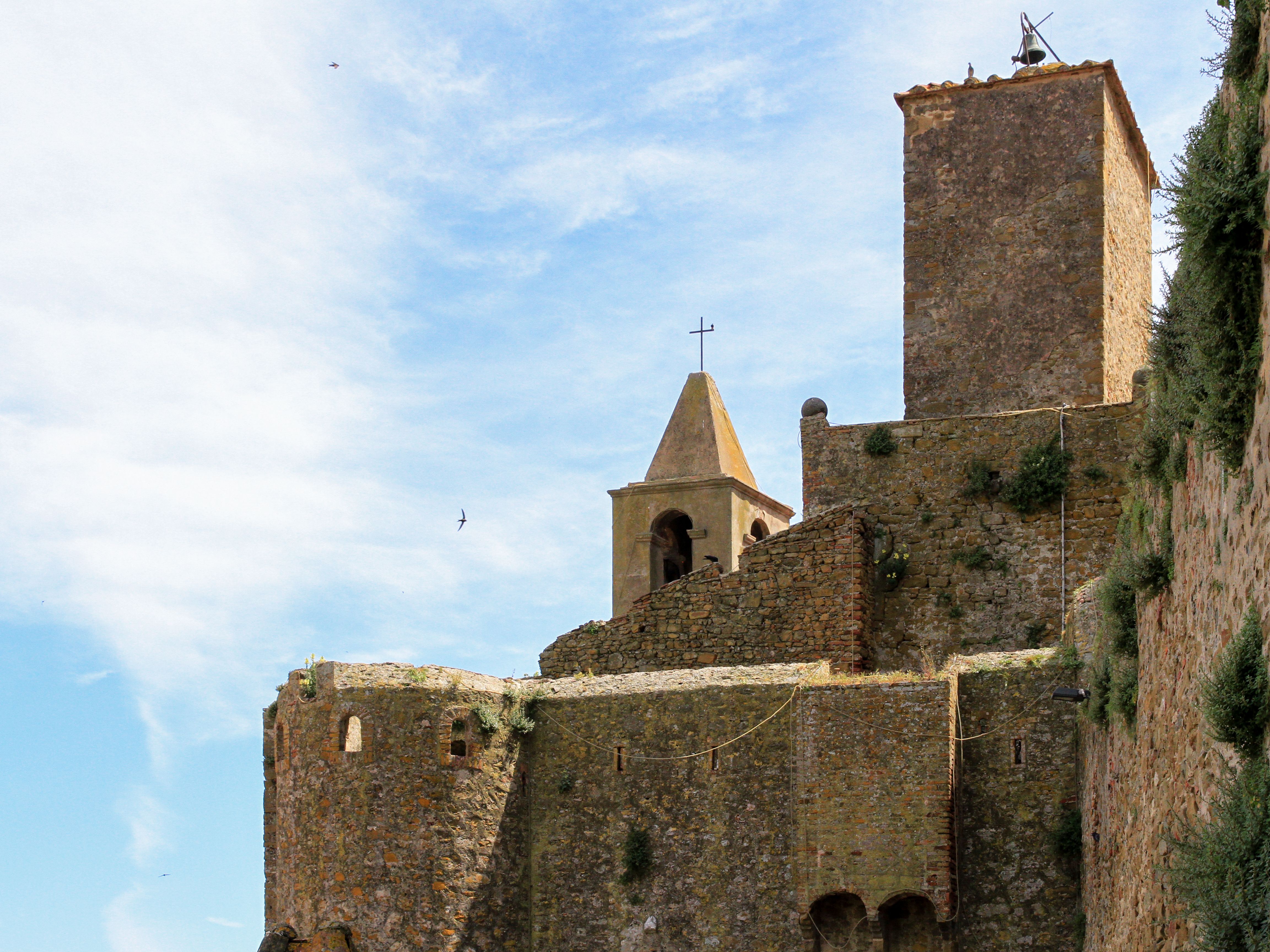 Free Historic stone fortress with towers and a bell tower under a clear blue sky. Stock Photo