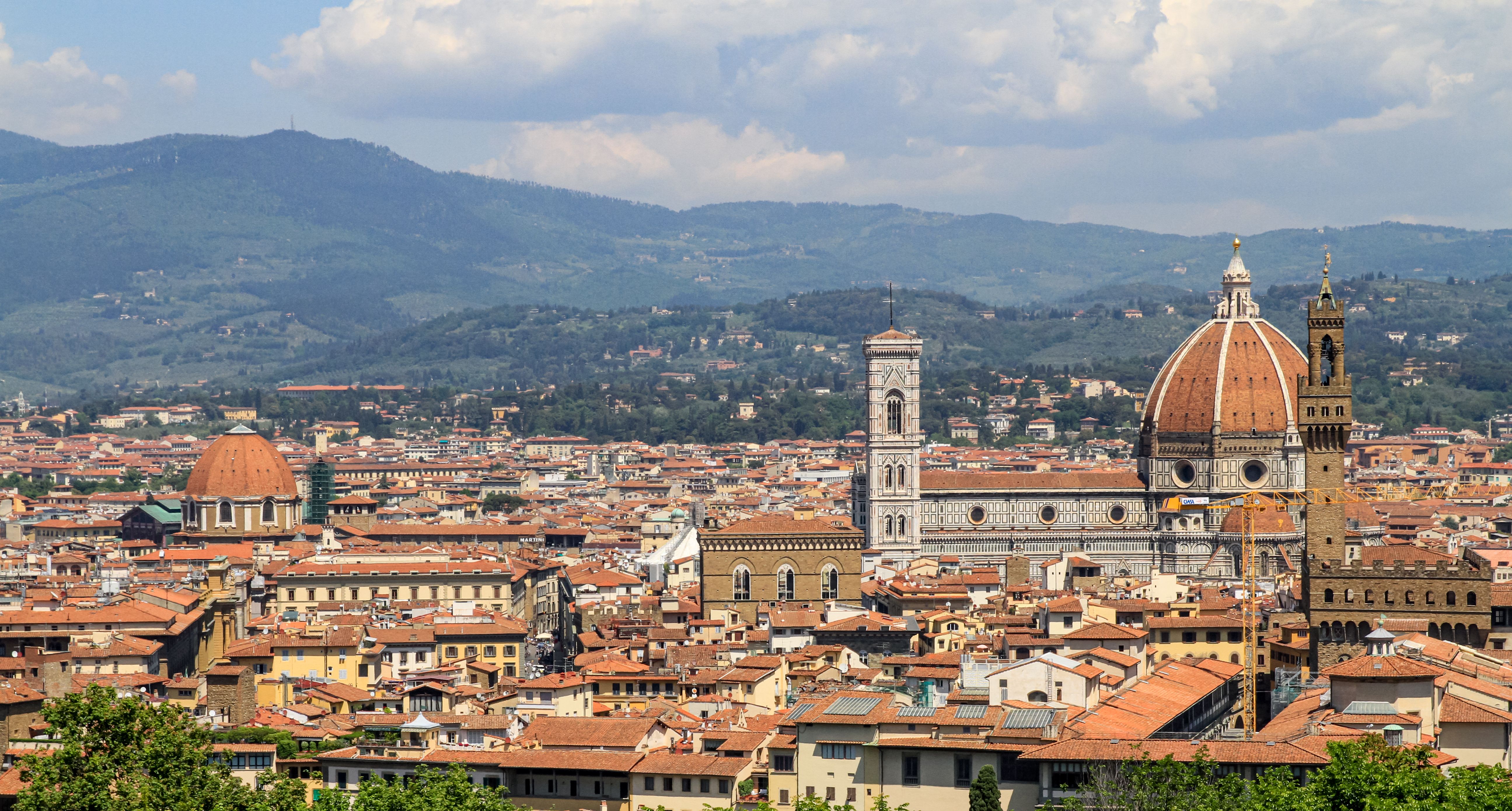 Free Panoramic view of Florence with the iconic Florence Cathedral and surrounding cityscape under a bright sky. Stock Photo