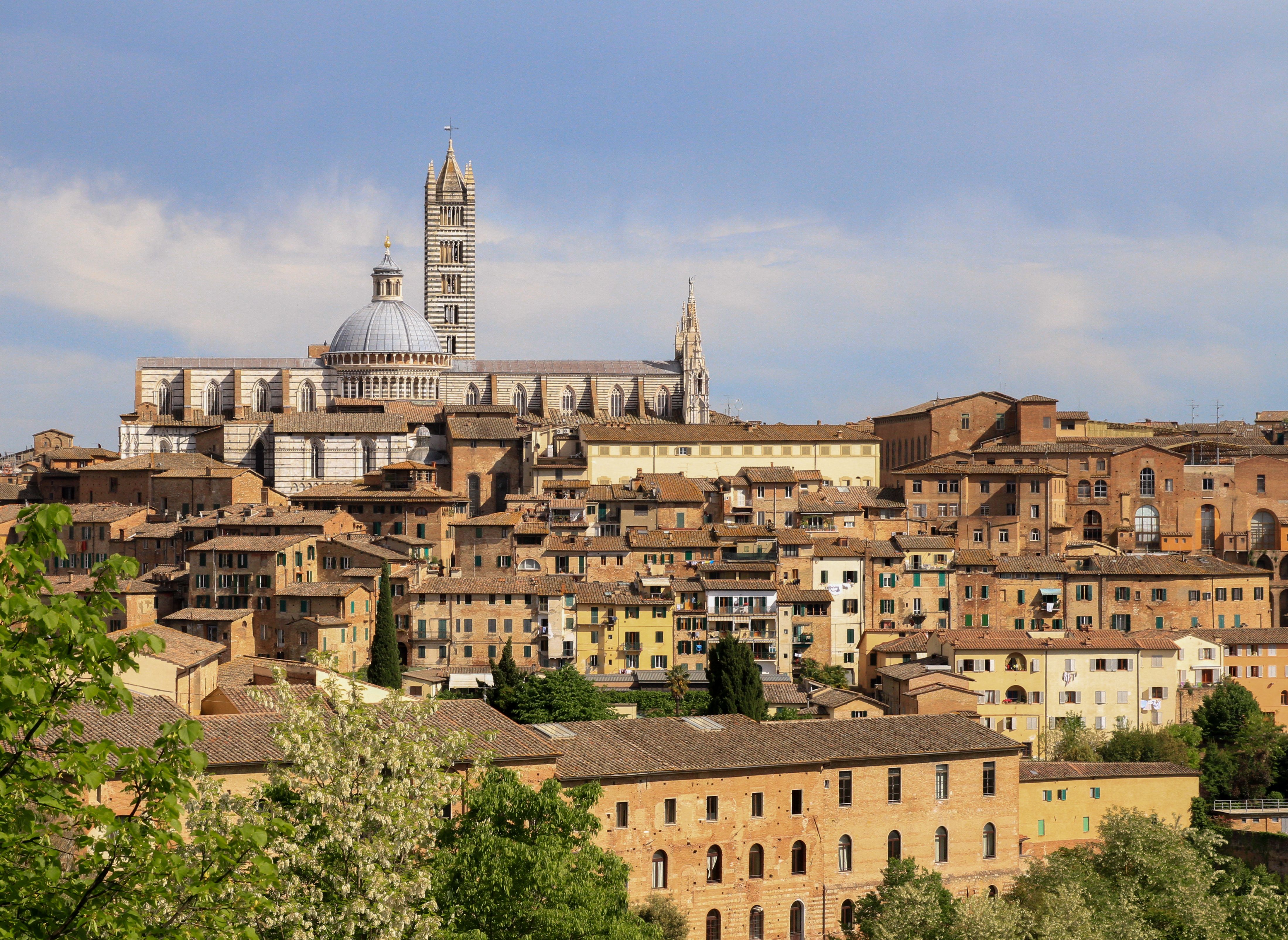 Free Spectacular view of Siena Cathedral amidst historic city buildings. Stock Photo