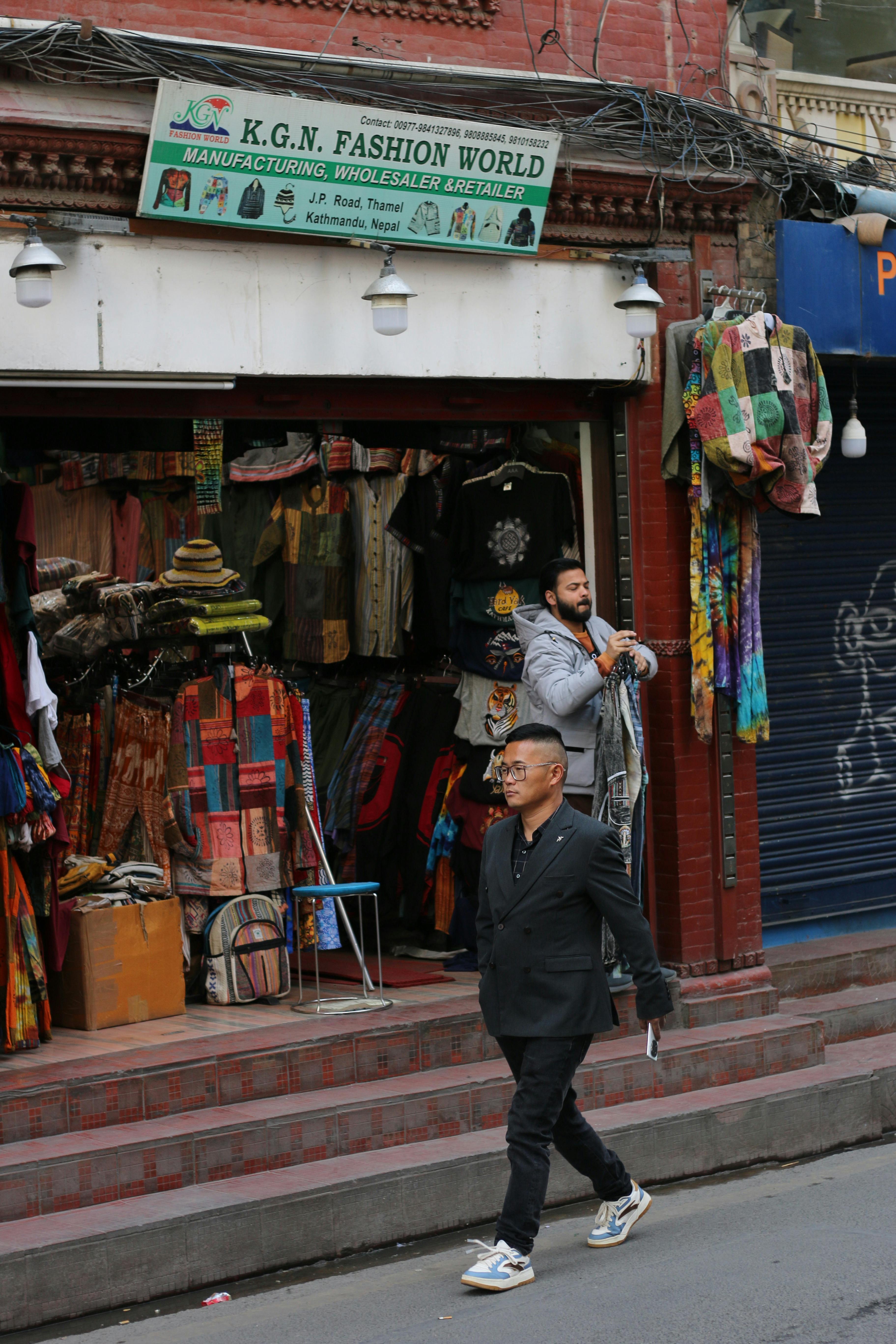 бесплатная Пешеходы проходят мимо магазина K.G.N. Fashion World в Катманду, Непал. Стоковое фото