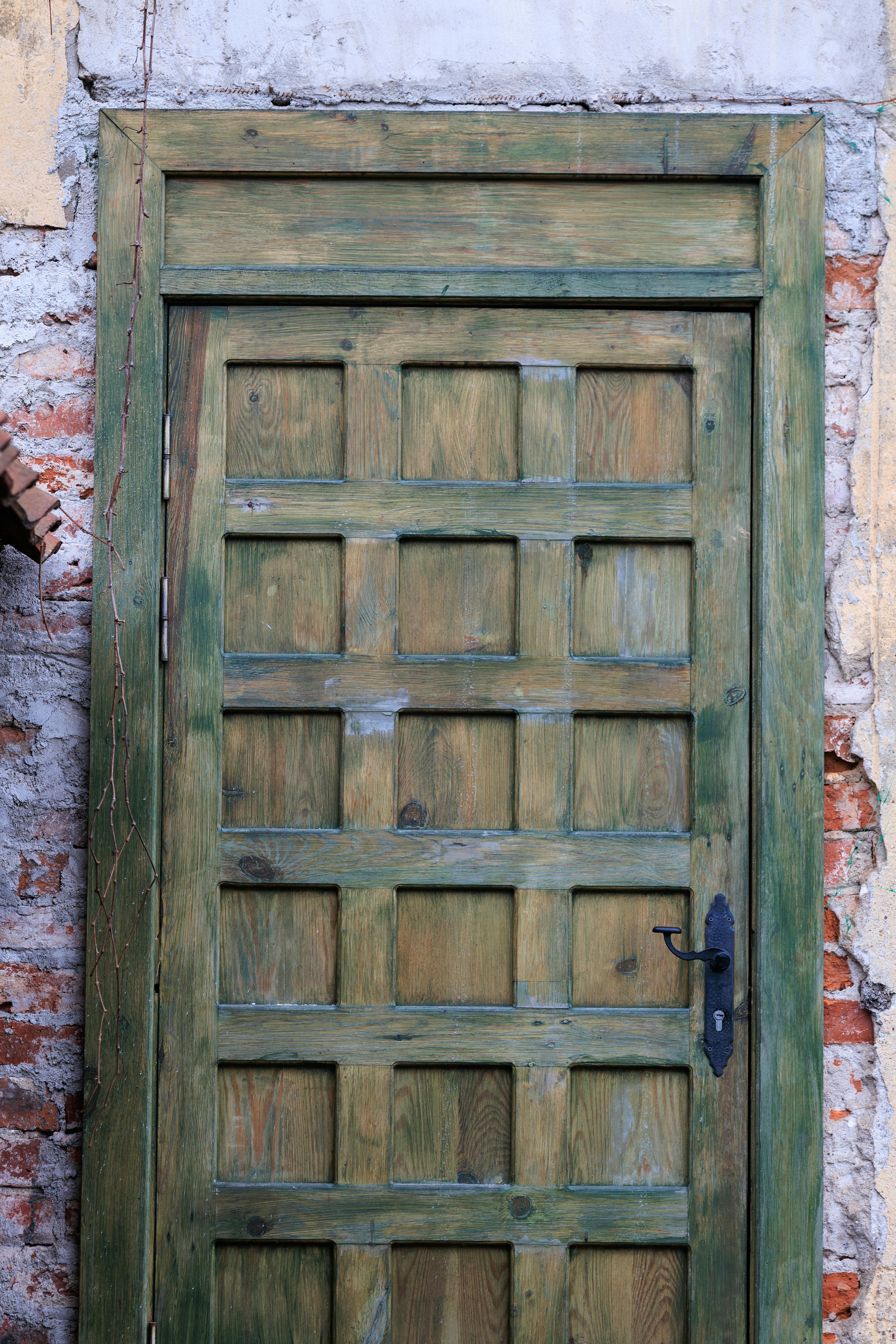 Gratis En rustikk tredør med avskallet maling og vintagedetaljer i Tsjernjakhovsk, Russland. Arkivbilde