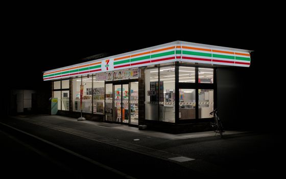 A brightly lit convenience store in Kyoto, Japan, at night.