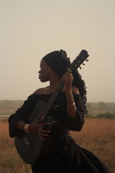 Captivating portrait of a woman with a guitar in a serene outdoor setting, evoking a sense of calm and creativity.