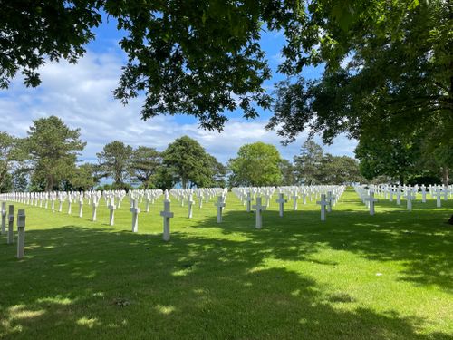 Free Rows of white crosses under a blue sky in a peaceful military cemetery with green grass. Stock Photo