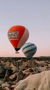 Majestic hot air balloons float over Cappadocia's unique landscape at sunrise, capturing adventure and tranquility.
