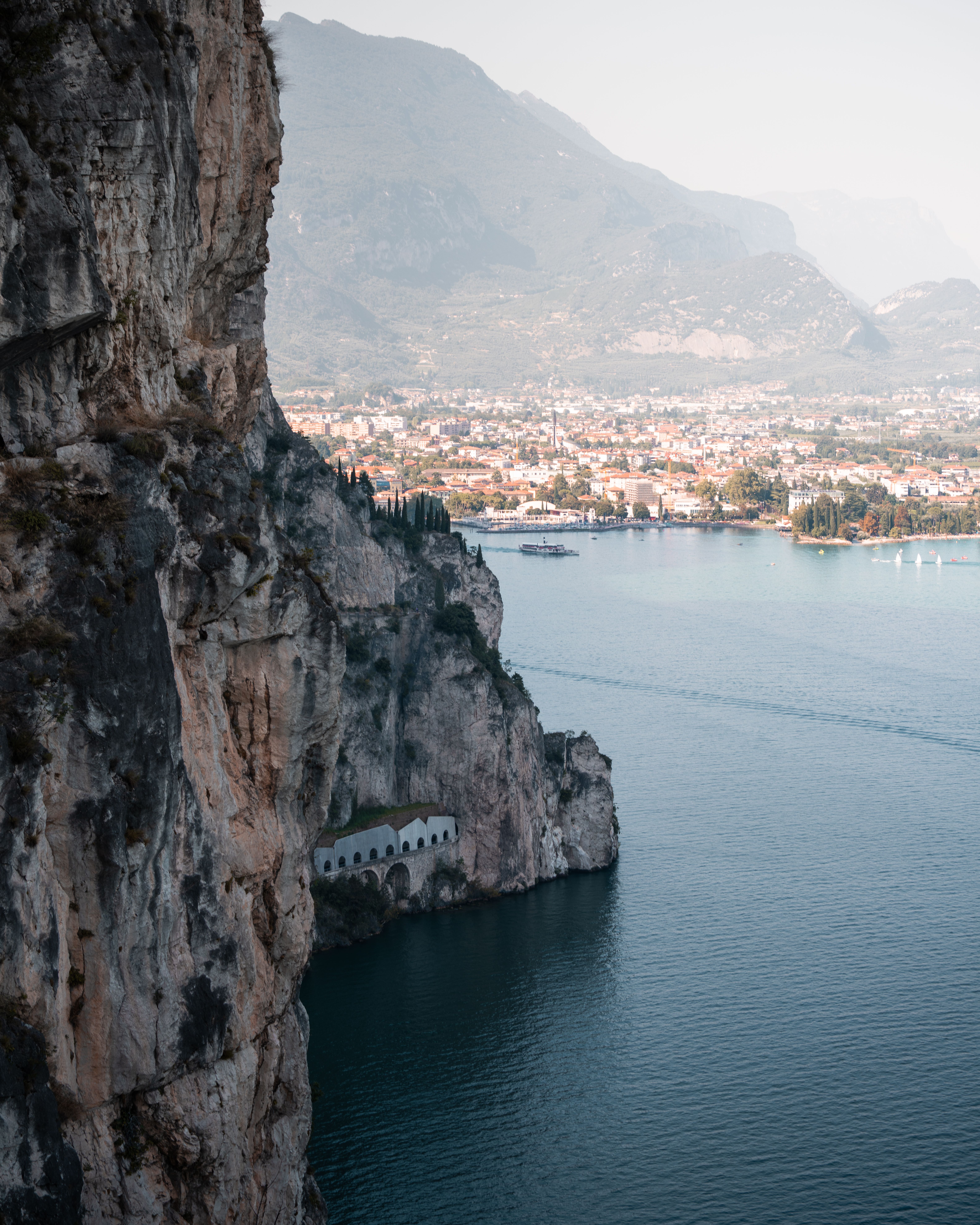 Breathtaking aerial view of Lake Garda's coastline from Riva del Garda, showcasing cliffs and a tranquil lake setting.