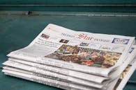 Stack of Newspapers with Headline on Poverty