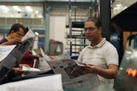 Newspaper Printing Press Workers Reading Latest News