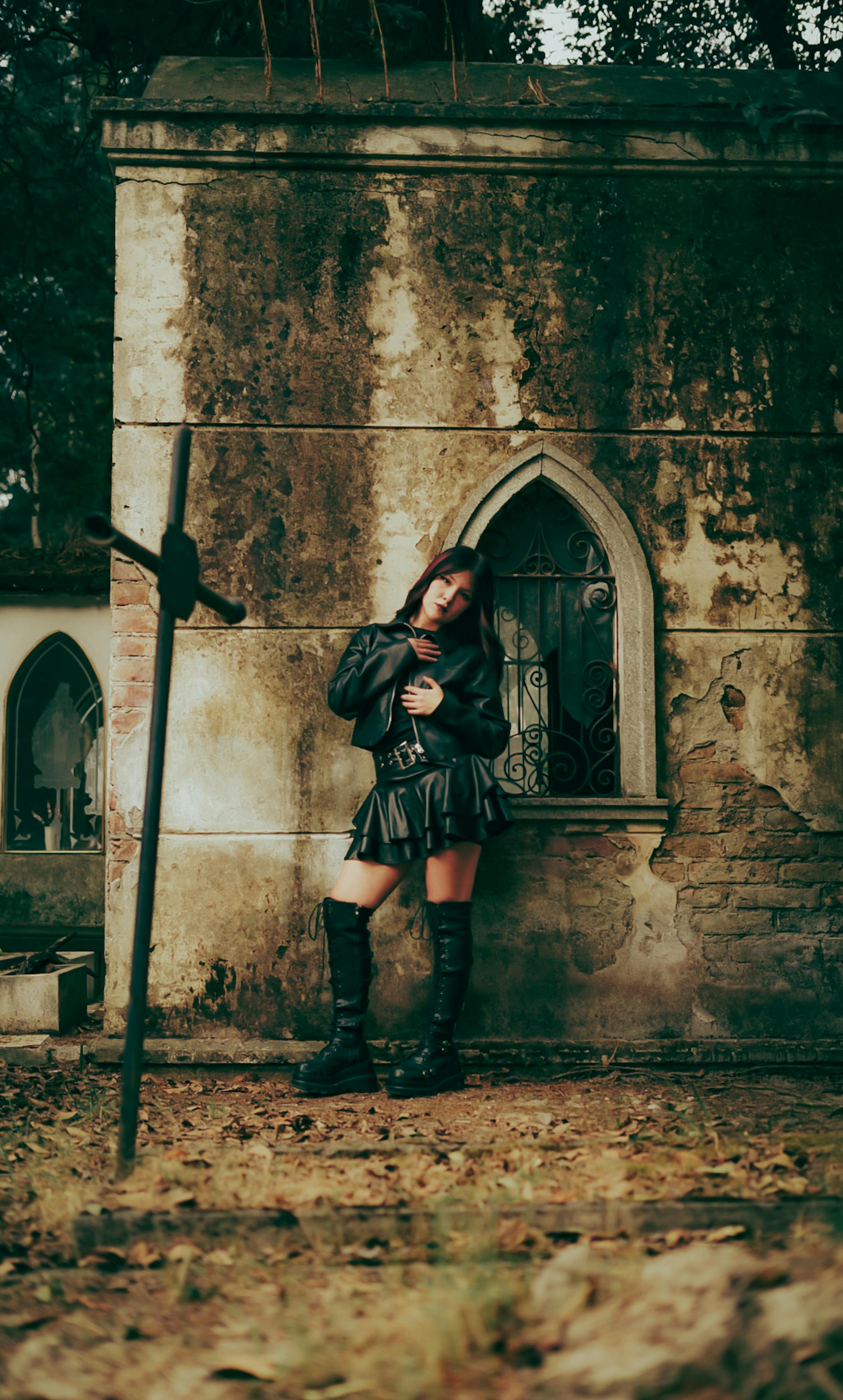 Δωρεάν Μια γυναίκα με γοτθική ενδυμασία ποζάρει δίπλα σε ένα ρουστίκ μαυσωλείο σε ένα υπαίθριο νεκροταφείο. Φωτογραφία από στοκ φωτογραφιών