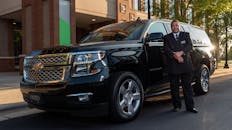 Professional Chauffeur Standing Beside Luxury SUV