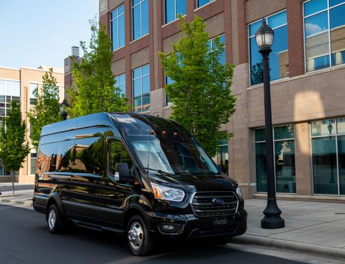 Free A sleek black van parked on a city street by a modern office building. Stock Photo