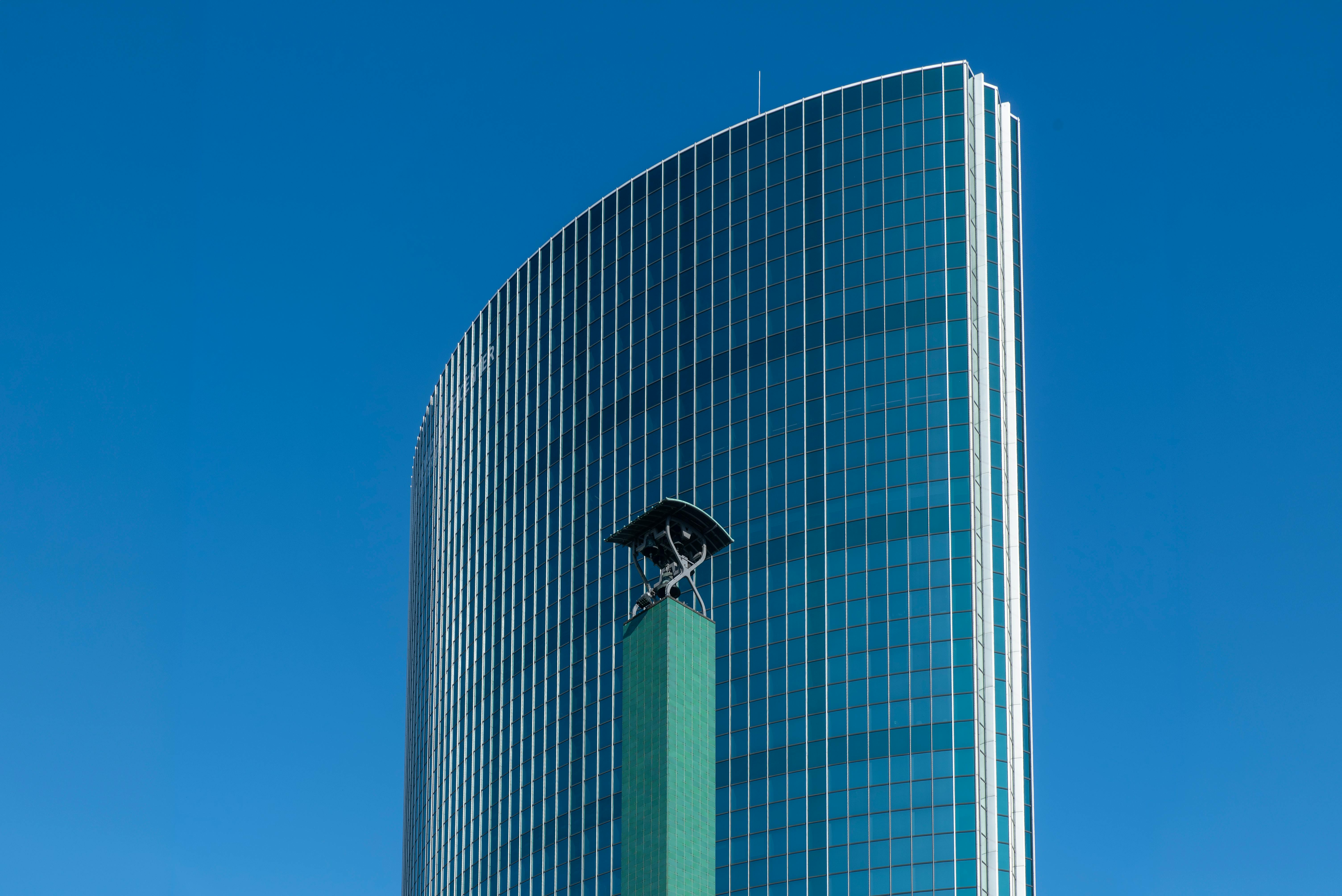 Kostenlos Ein hoher, moderner Wolkenkratzer in Rotterdam mit Glasfassade und klarem, blauem Himmel, der zeitgenössische Architektur präsentiert. Stock-Foto