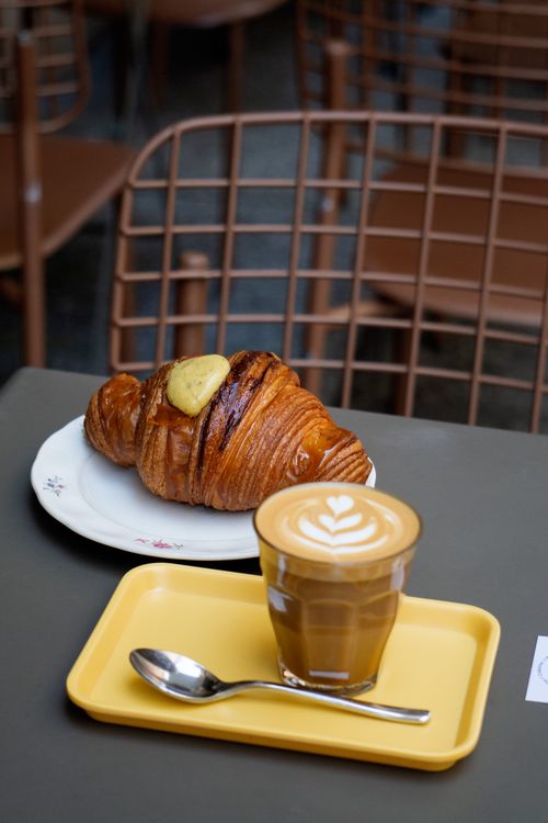 Free Croissant and latte on a stylish café table, perfect breakfast scene. Stock Photo