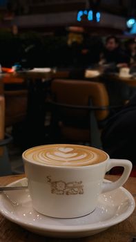 Warm latte with heart art in a cozy cafe setting, perfect for coffee enthusiasts.