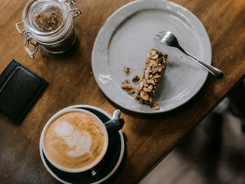 Free Cappuccino in Black Ceramic Mug on White Ceramic Round Plate Stock Photo