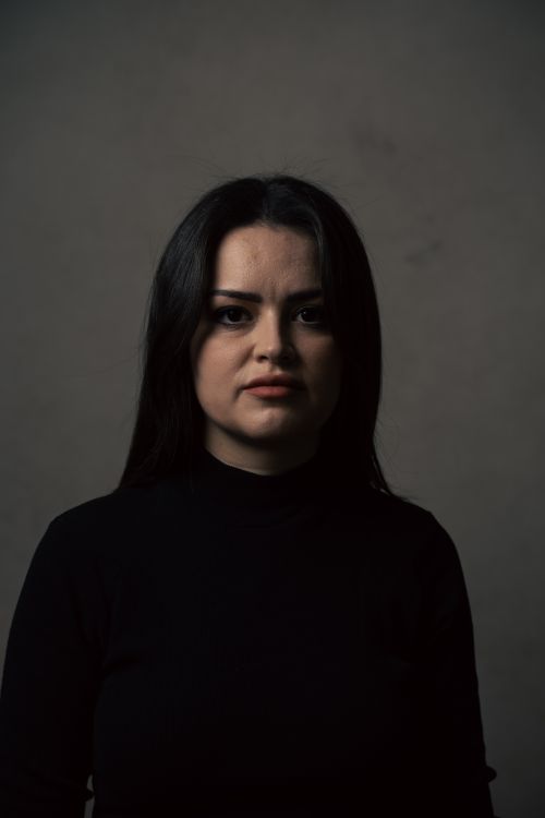 Free Dramatic portrait of a woman in a dark turtleneck with a moody tone. Stock Photo
