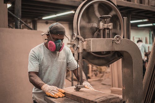 Free Man Working on Wooden Plank Using a Machine Stock Photo