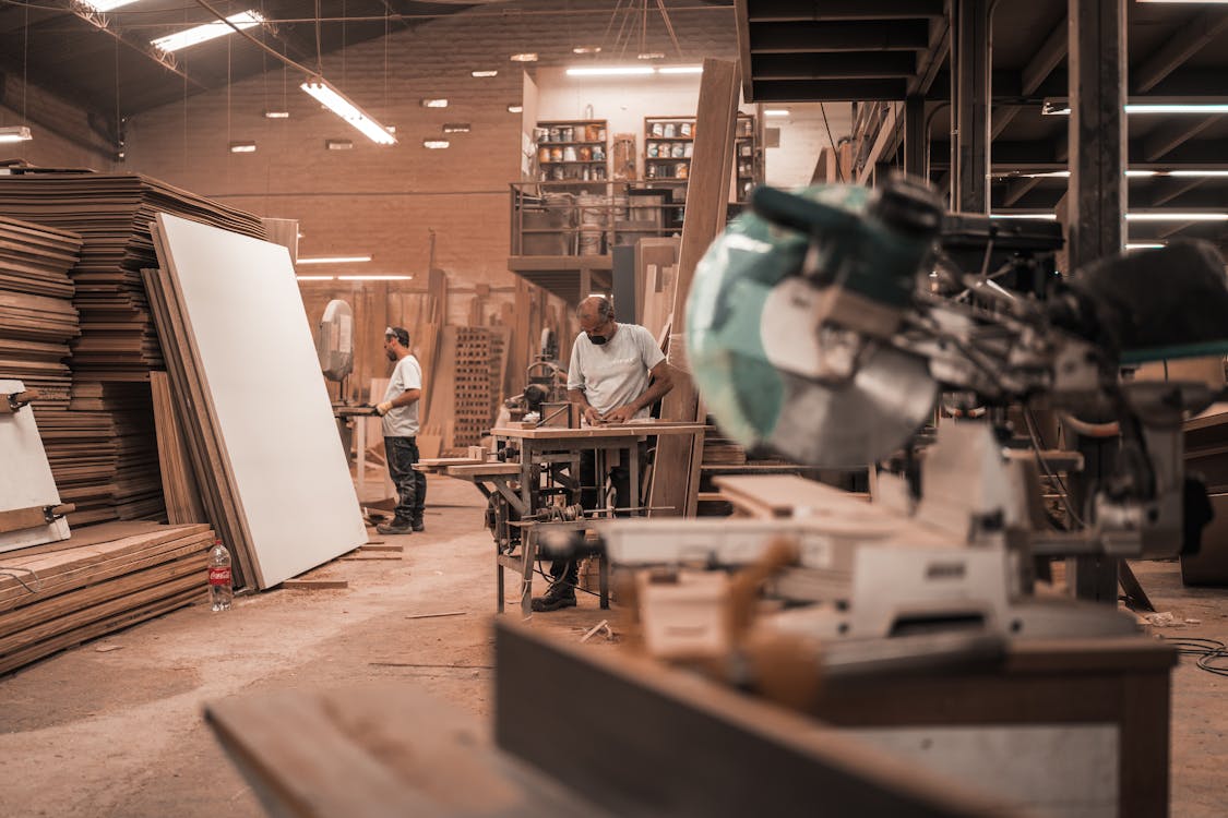 Man in White Shirt Standing Near Brown Wooden Table