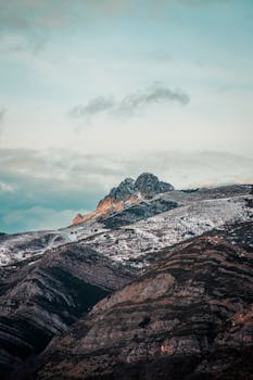 黎明时分，白雪皑皑的山脉在天空下展现出自然美景