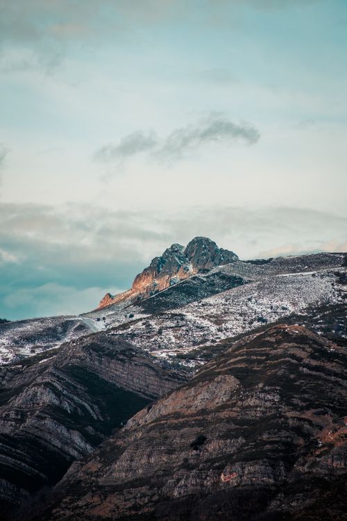 Free Scenic view of snow-capped mountains under a pastel sky at dawn, showcasing natural beauty. Stock Photo