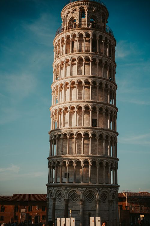 Free Capture of the renowned Leaning Tower of Pisa with a clear blue sky backdrop. Stock Photo