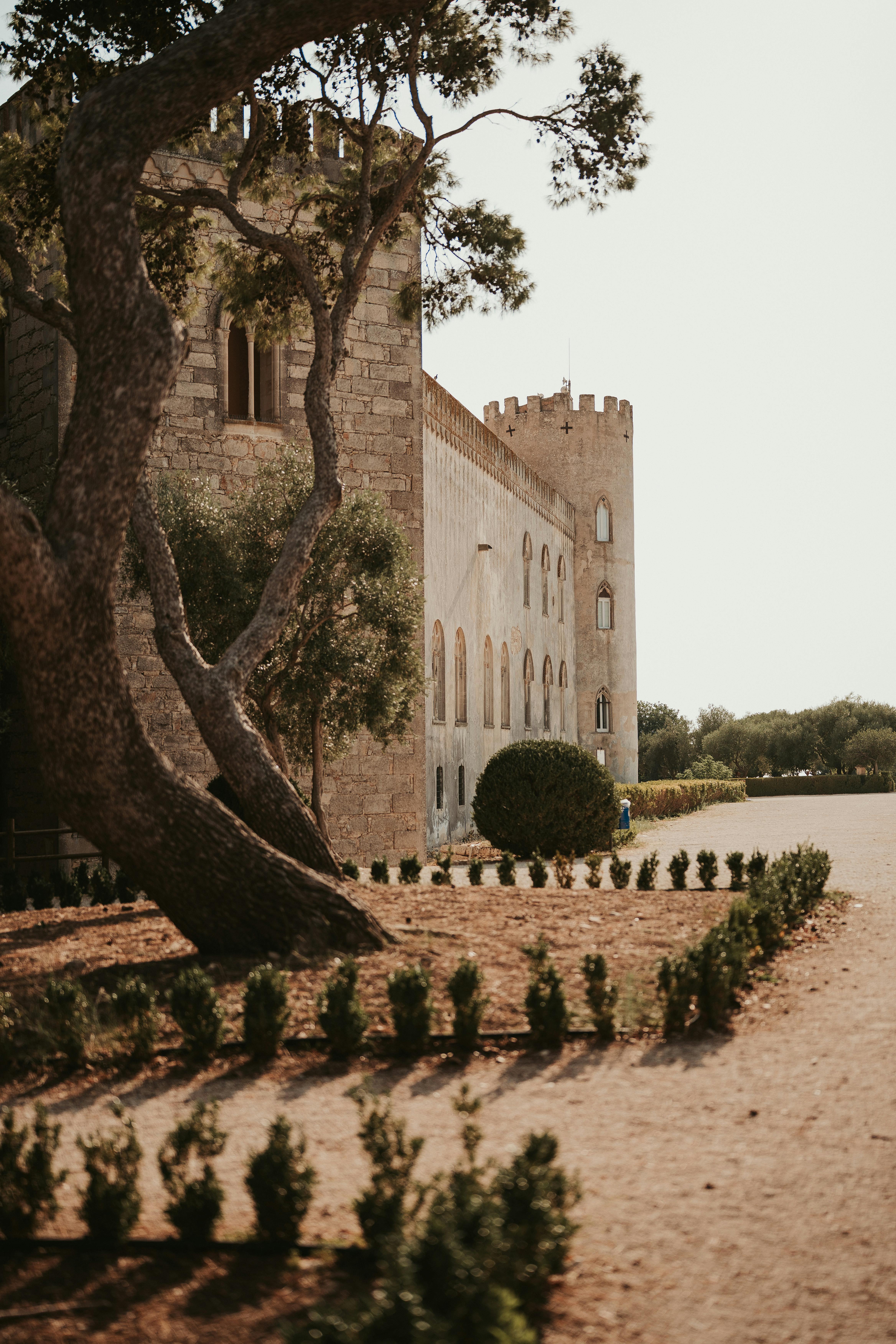 Free Beautiful exterior of the historic Donnafugata Castle in Sicily, Italy, surrounded by lush gardens. Stock Photo