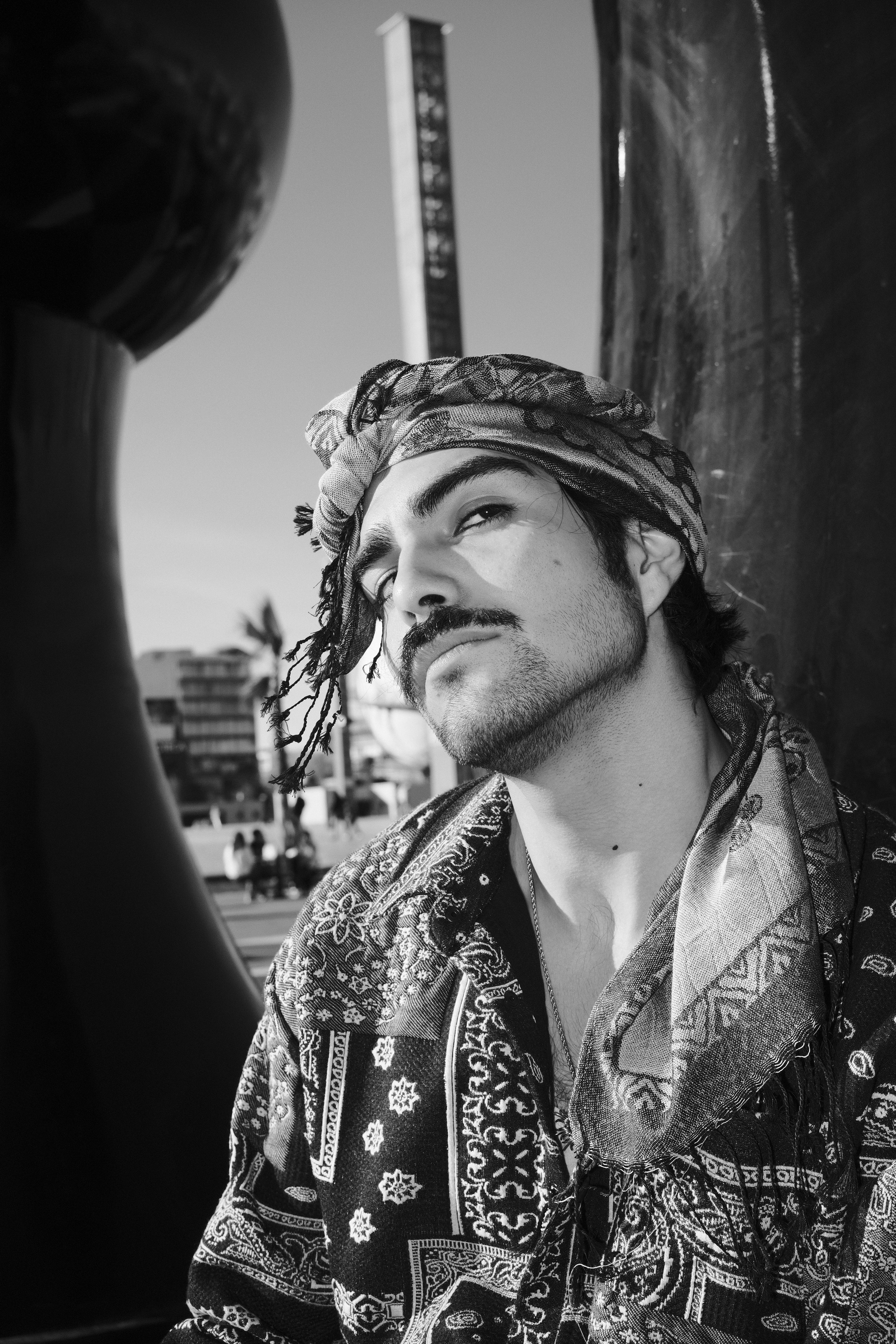 Gratis Retrato en blanco y negro de un hombre al aire libre con ropa estampada, que evoca una sensación clásica y artística. Foto de stock