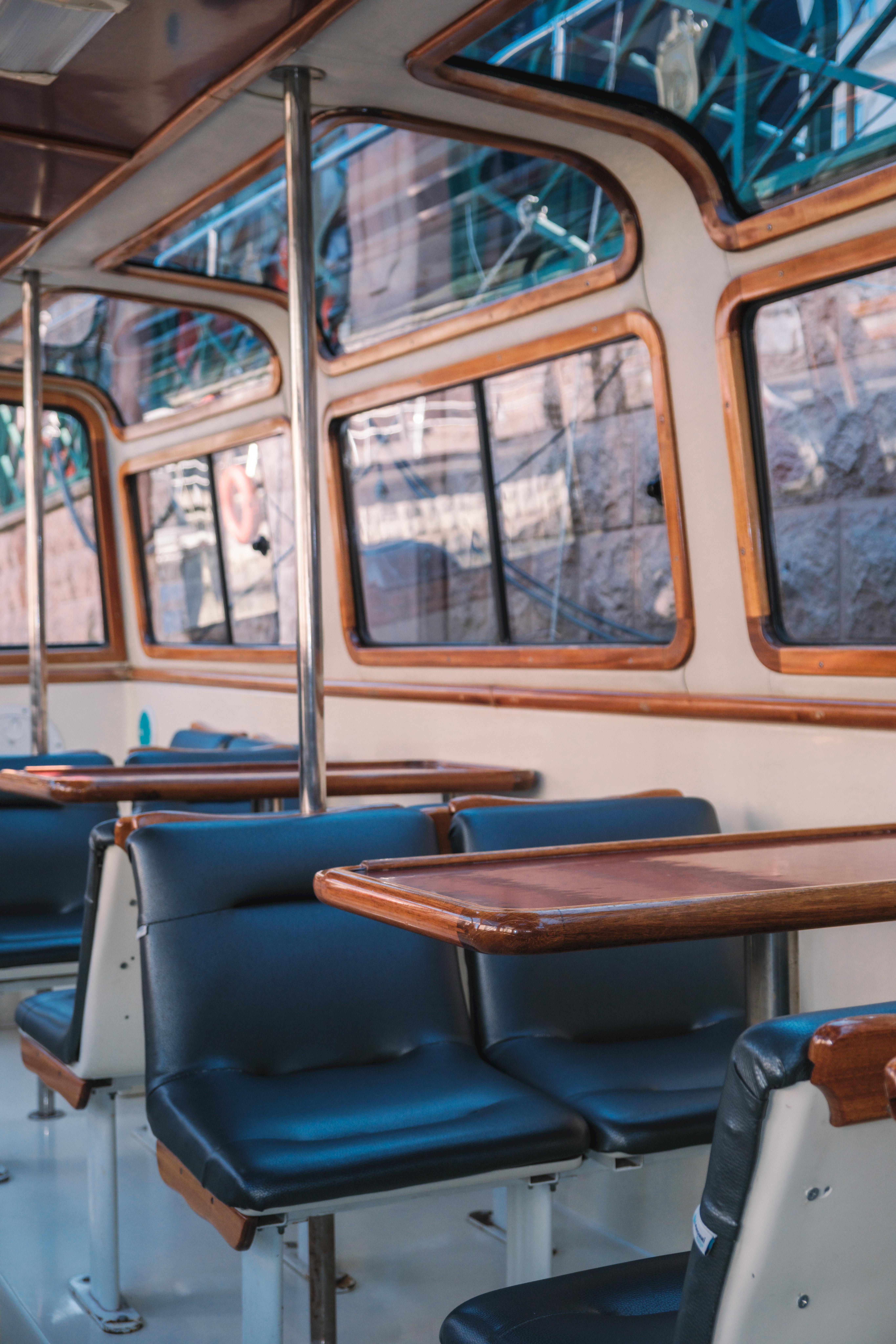 Gratis Interior trem bergaya retro dengan aksen kayu dan tempat duduk berwarna biru, menghadirkan suasana perjalanan yang penuh nostalgia. Foto Stok