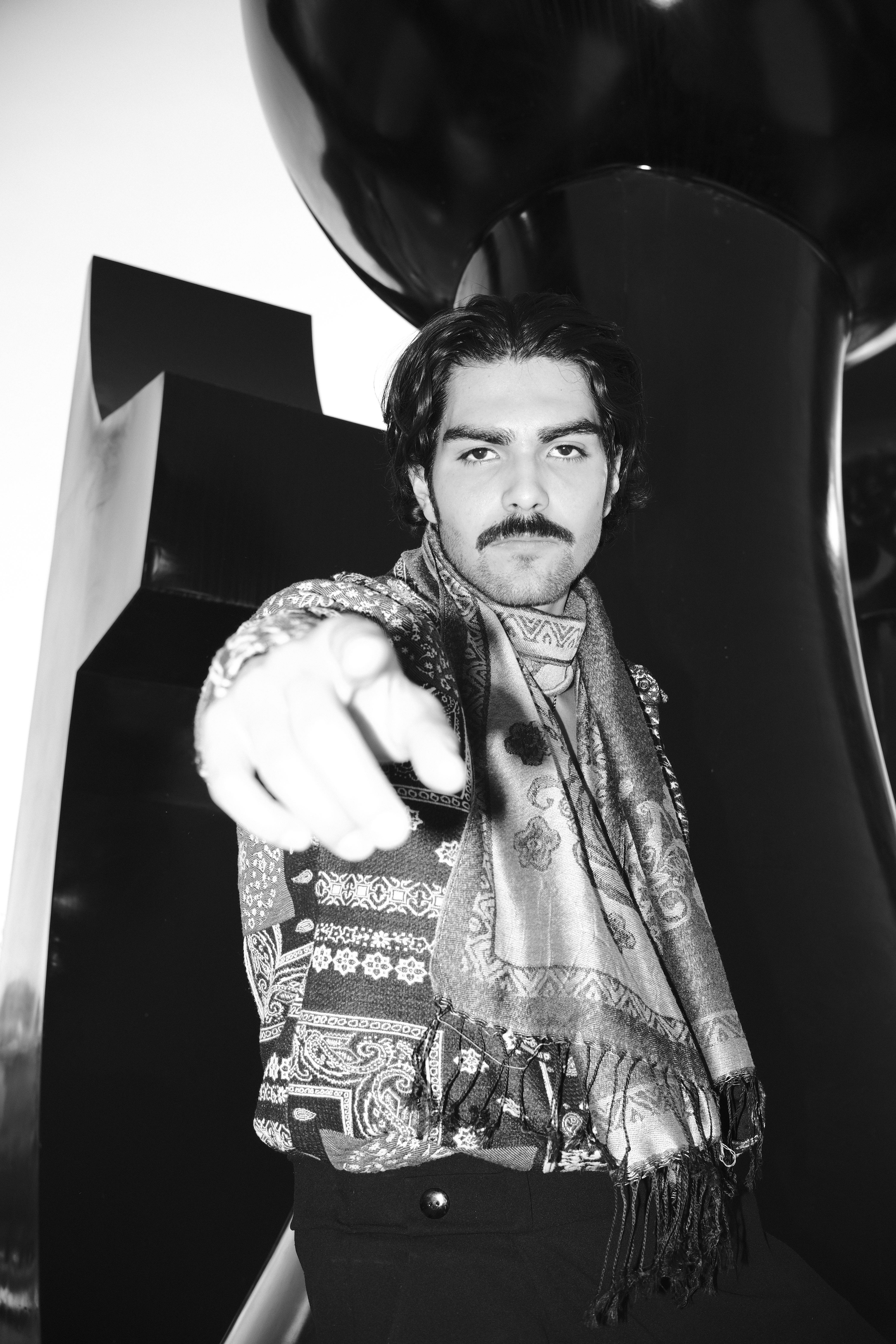 Free Stylish man with a scarf in black and white, pointing at the camera. Stock Photo