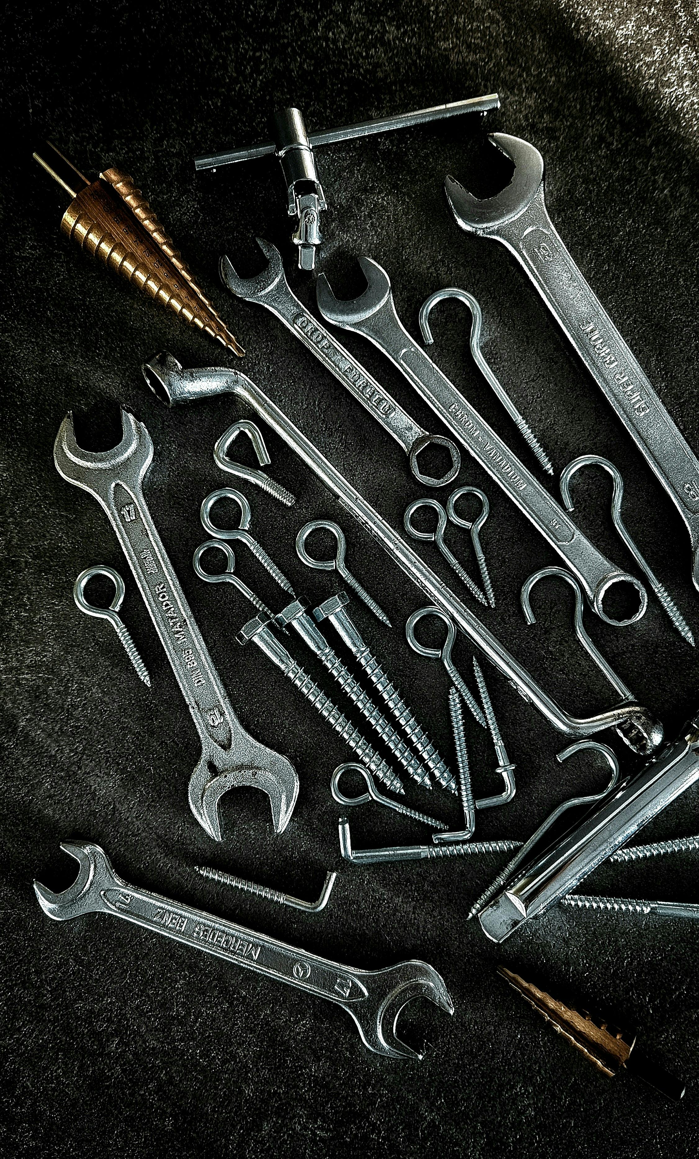 Detailed image of various metal hand tools on a workshop floor, perfect for DIY and craftsmanship themes.