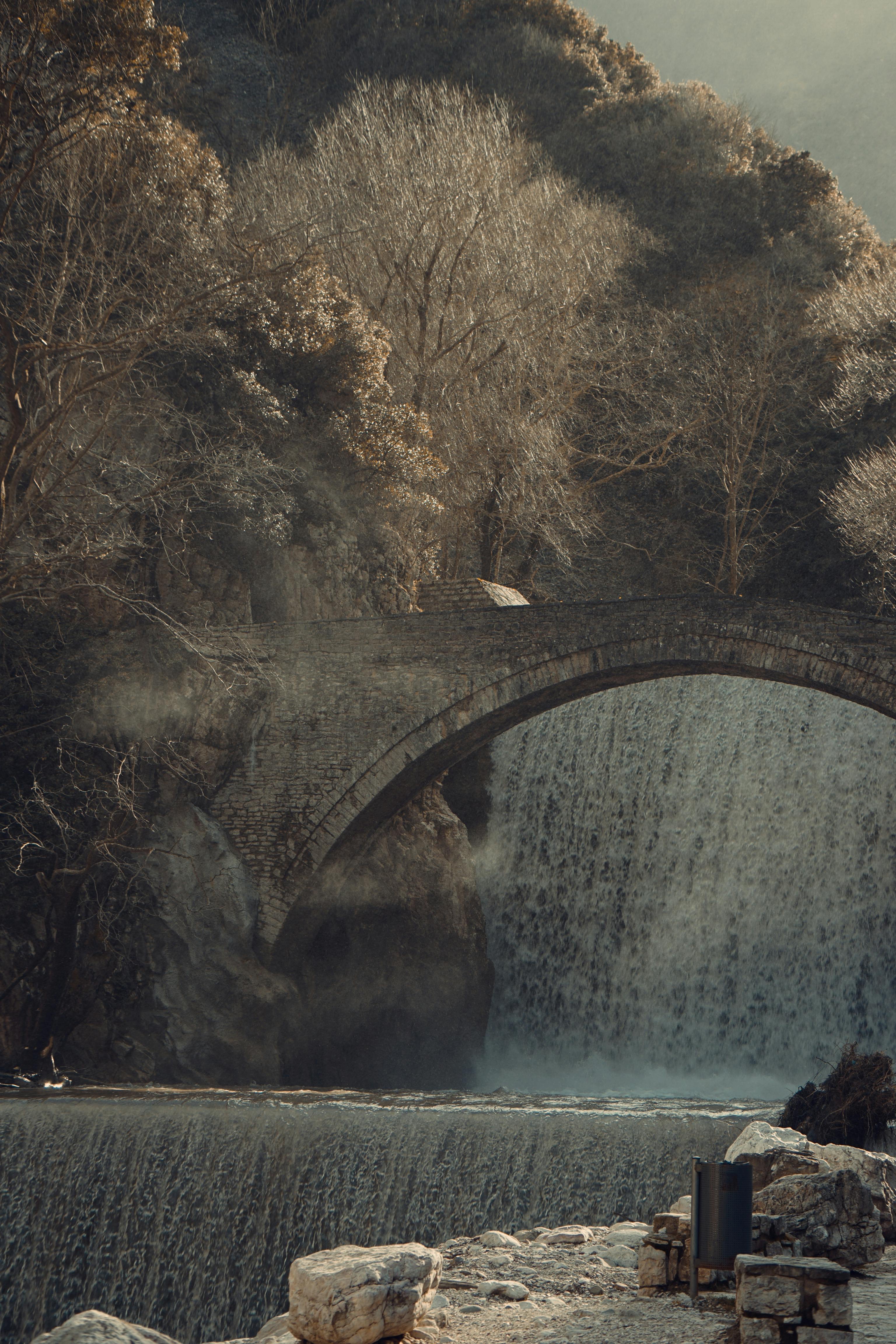 бесплатная Исторический каменный арочный мост через каскадный водопад в Трикале, Греция. Стоковое фото