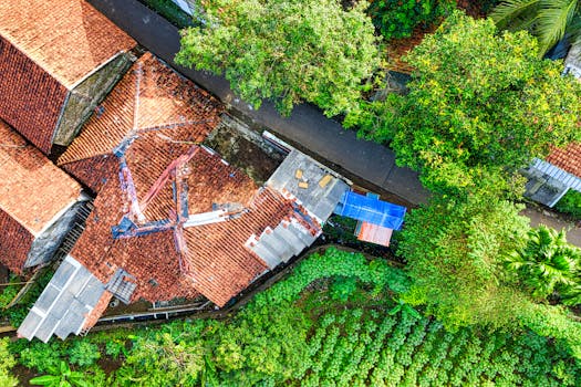 A vibrant aerial shot showcasing rustic houses and lush greenery in West Java, Indonesia.
