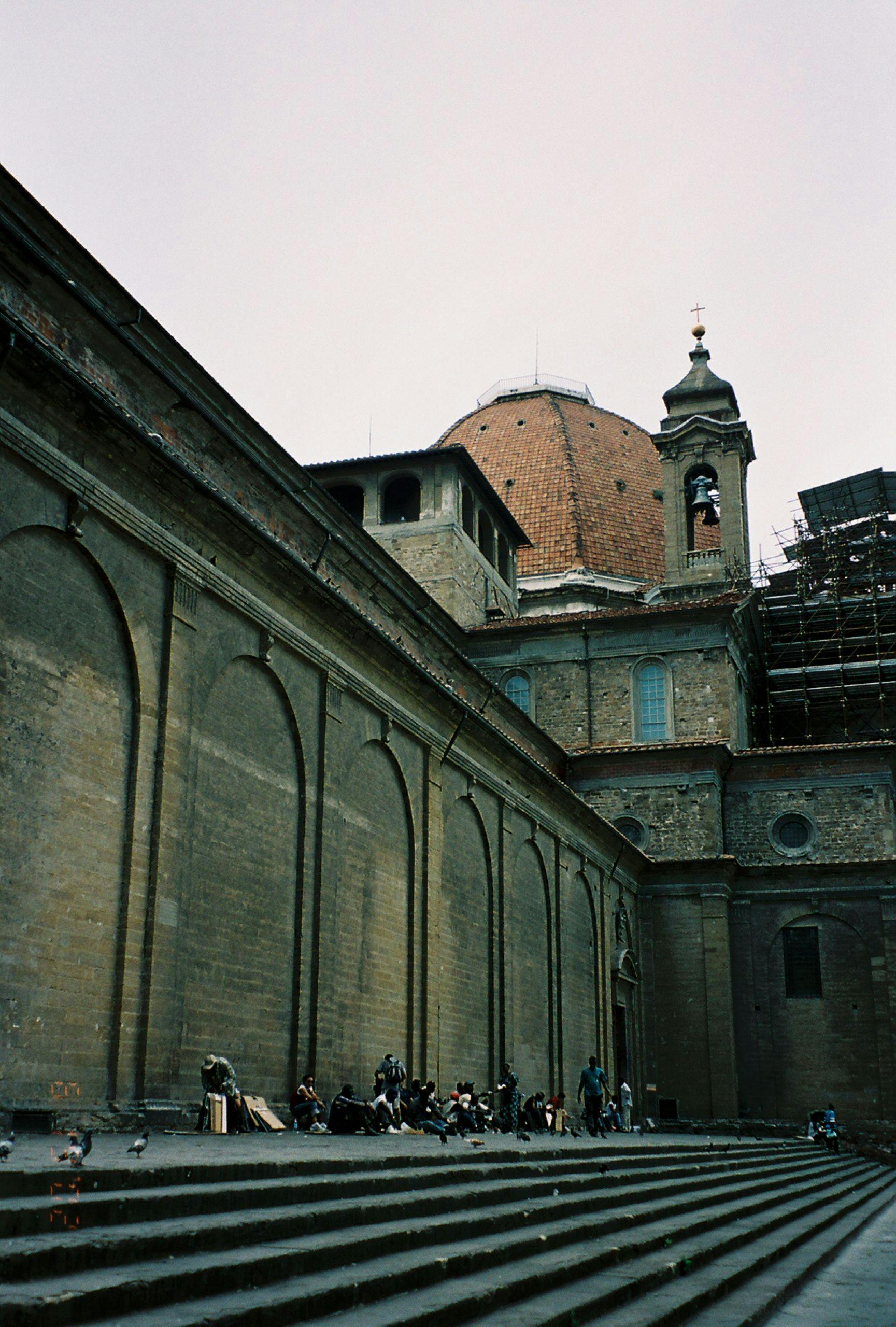 бесплатная Туристы отдыхают на лестнице исторической церкви во Флоренции, Италия. Стоковое фото