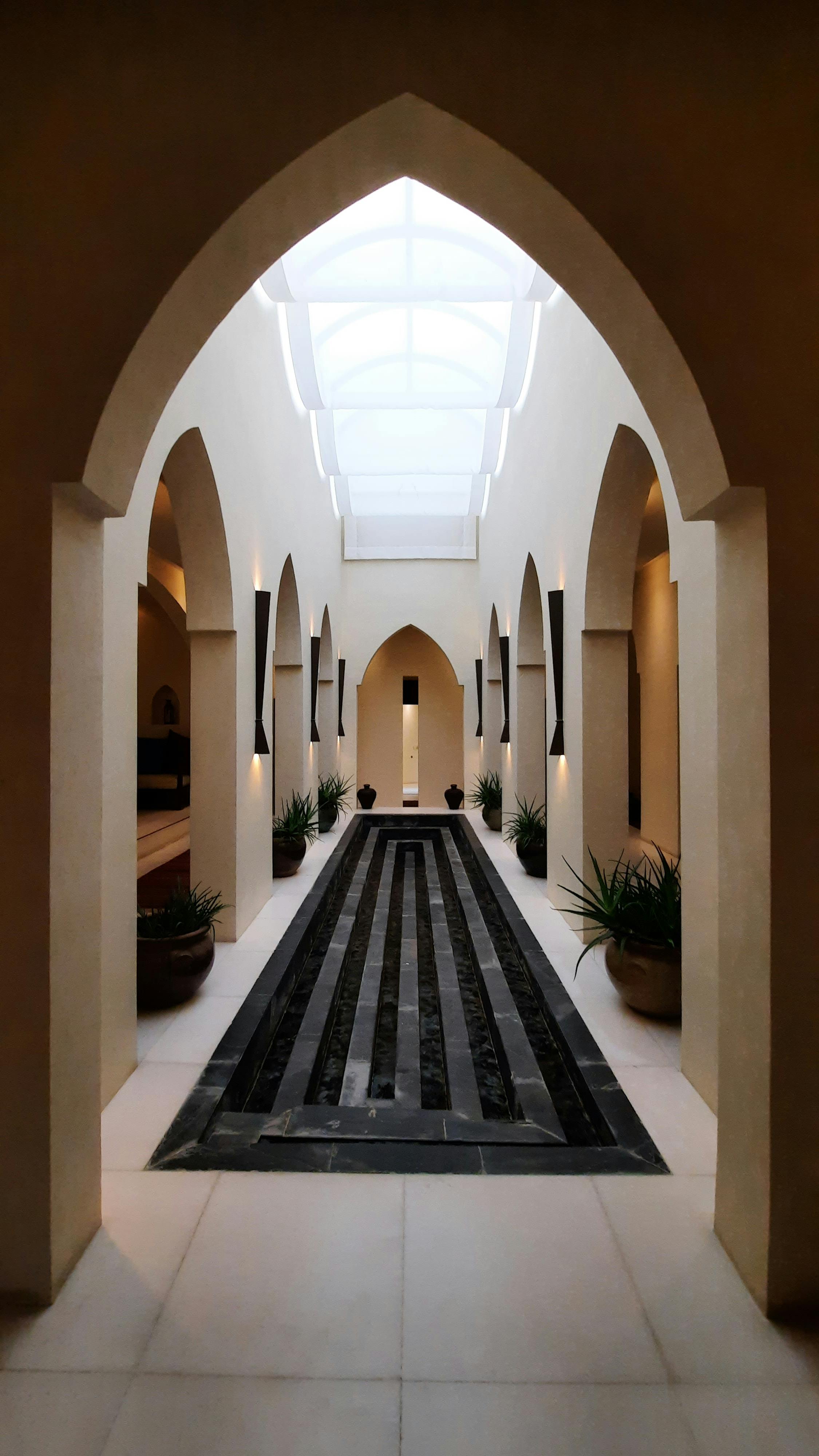 無料 美しいアーチ型の建築とモダンなデザイン要素が特徴の静かな屋内廊下。 写真素材