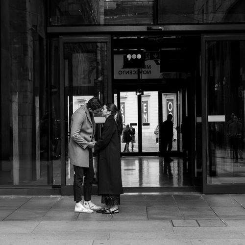 Free A couple shares an intimate moment in an urban setting, capturing romance in Milan, Italy. Stock Photo