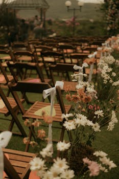 Charming outdoor wedding setup with wooden chairs and floral arrangements, perfect for a spring or summer ceremony.