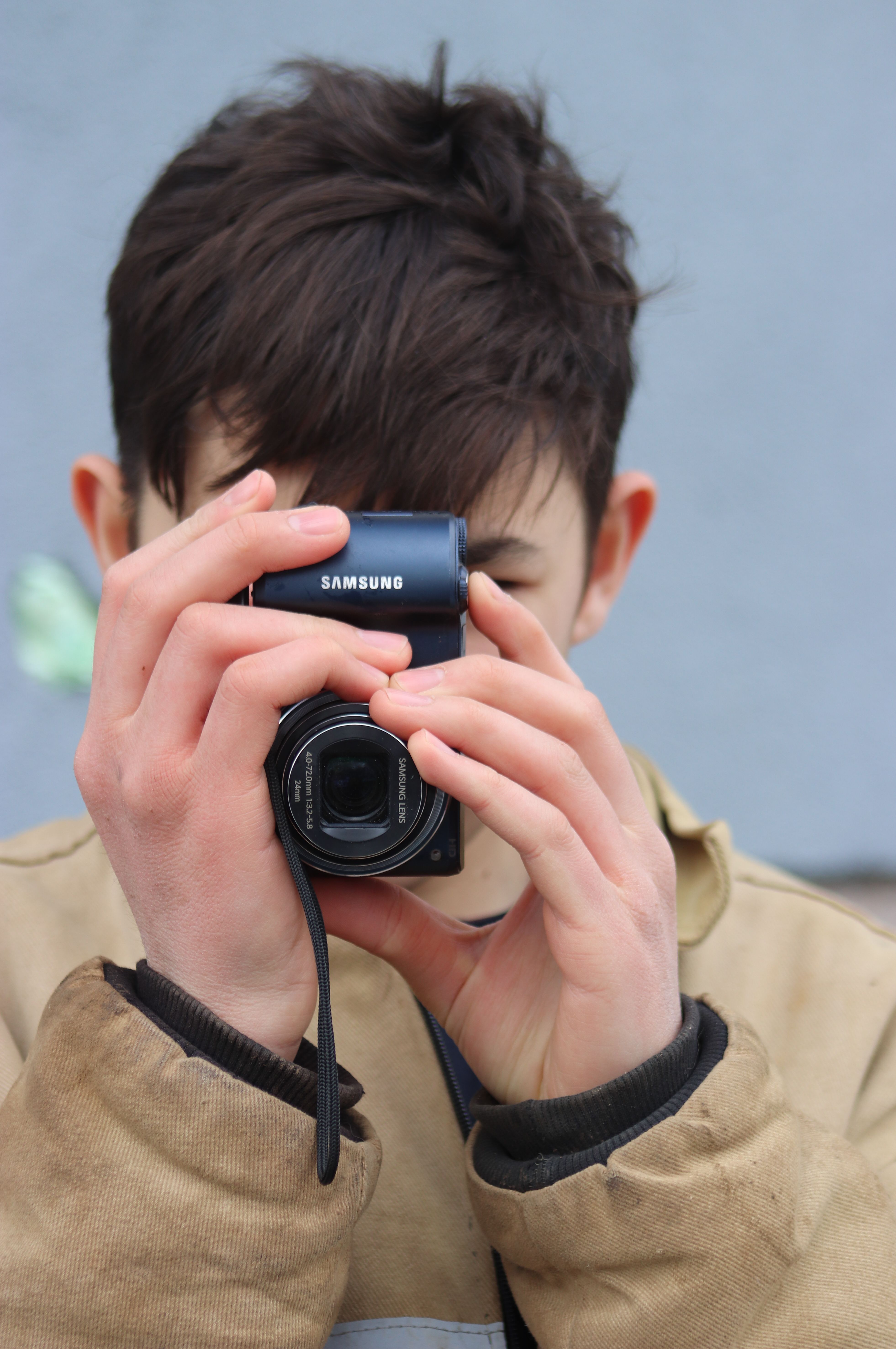 Portrait of a young person capturing moments with a compact camera.